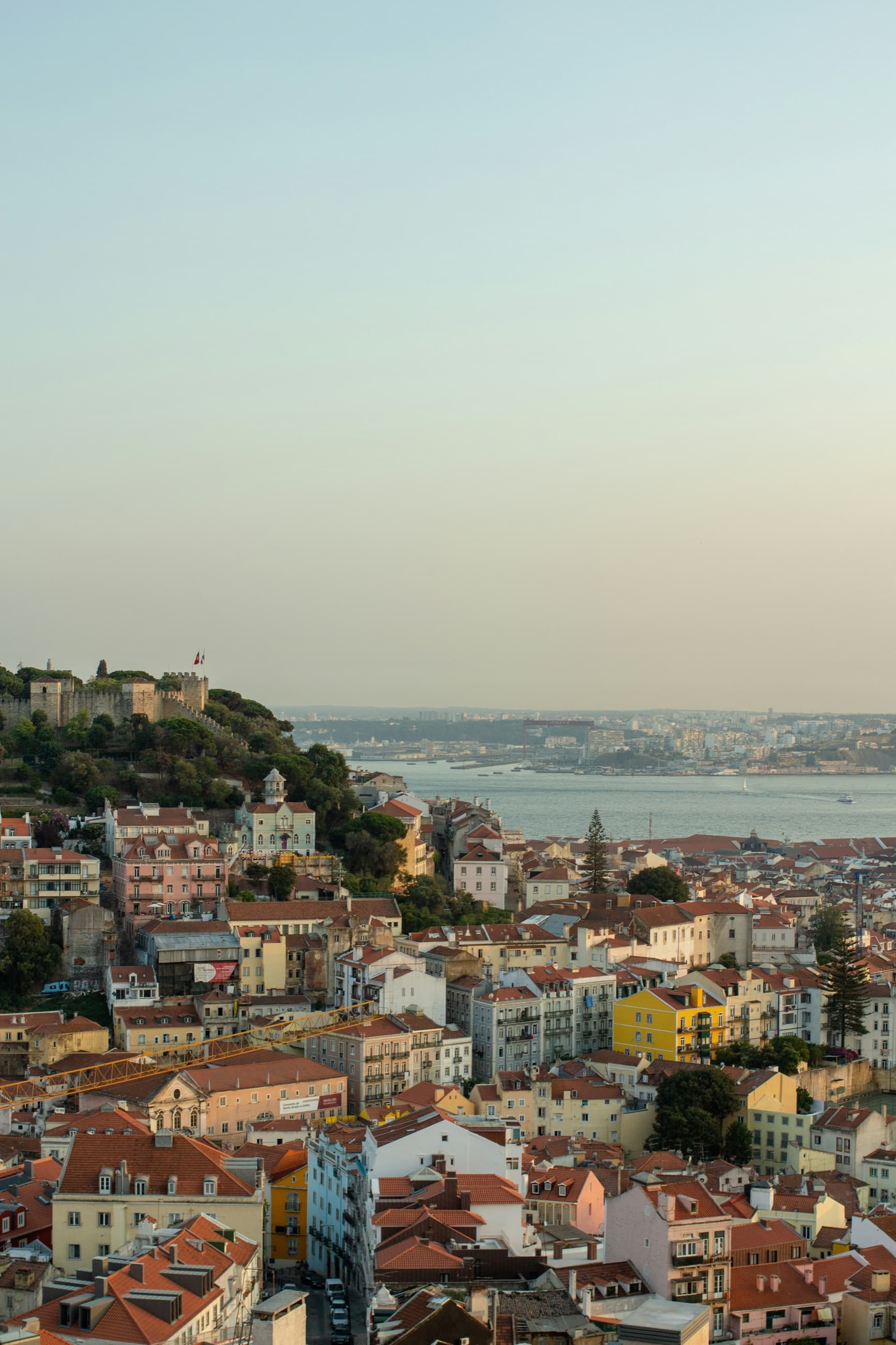 Lisbon at golden hour, the castle above the rooftops and the Tagus beyond